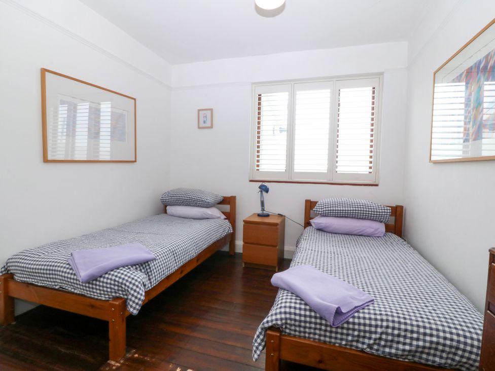 A bedroom with twin beds and a nightstand at Faraway in Rhosneigr