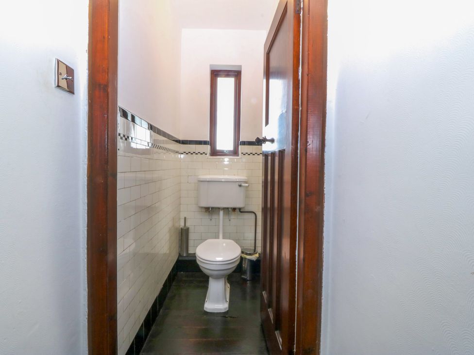 A bathroom with toilet and window at Faraway in Rhosneigr