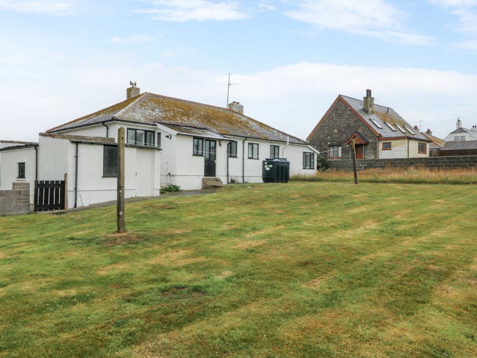 A house with a yard and grass at Faraway in Rhosneigr