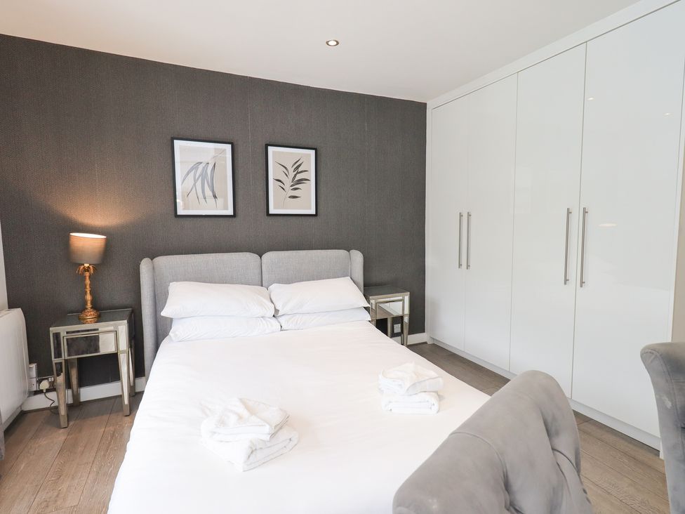 A bedroom with a bed, bedside table, and wardrobe at Bowness Central in Bowness-On-Windermere