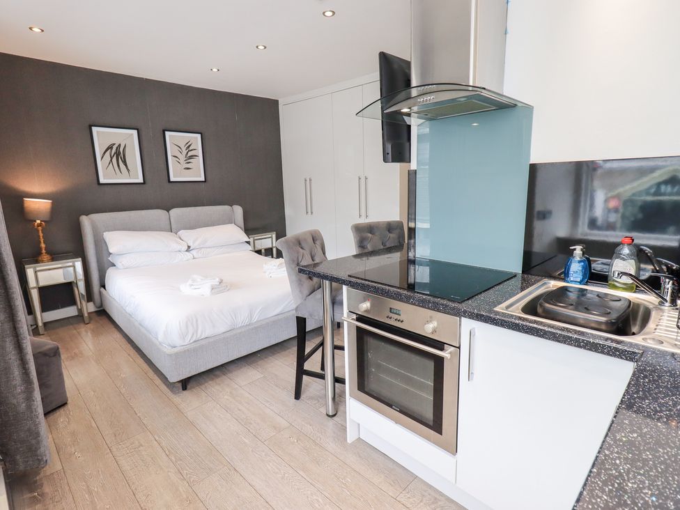 A studio apartment with a bed, kitchenette, and seating area at Bowness Central in Bowness-On-Windermere