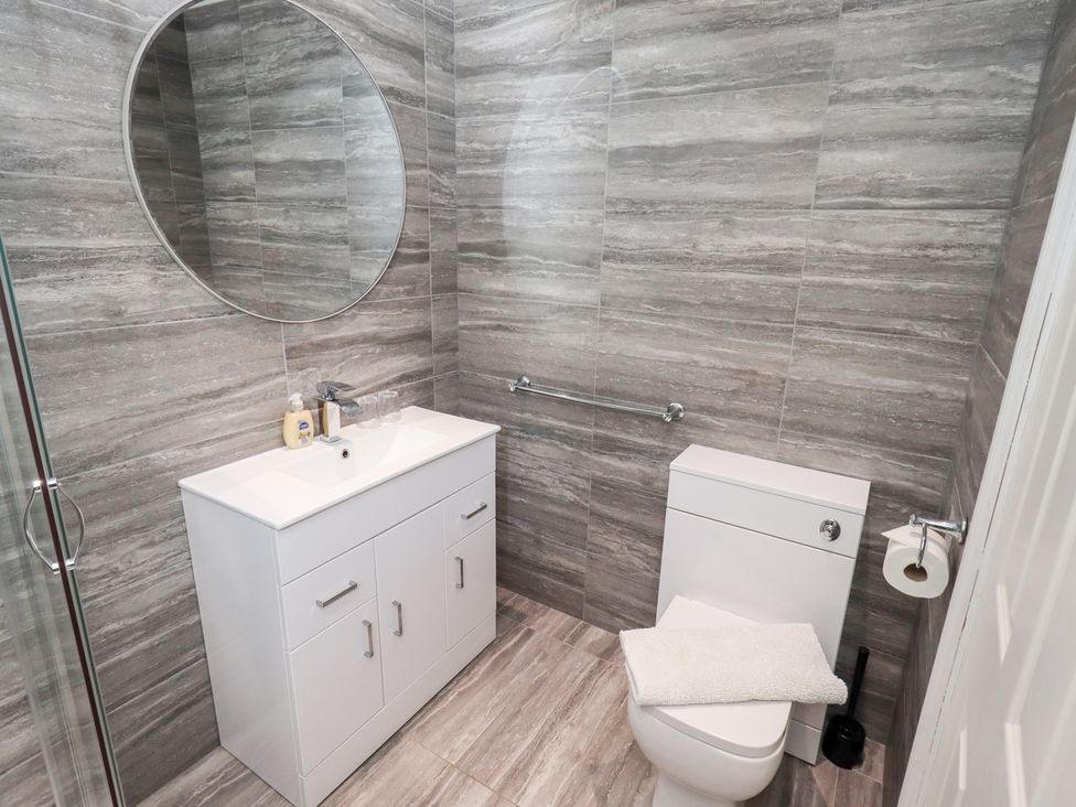A bathroom with a sink, toilet and mirror at Bowness Central in Bowness-On-Windermere