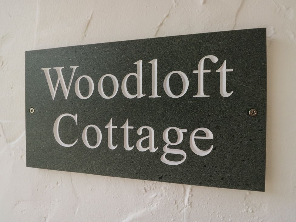 A sign displaying Woodloft Cottage at Woodloft Cottage Elterwater near Chapel Stile
