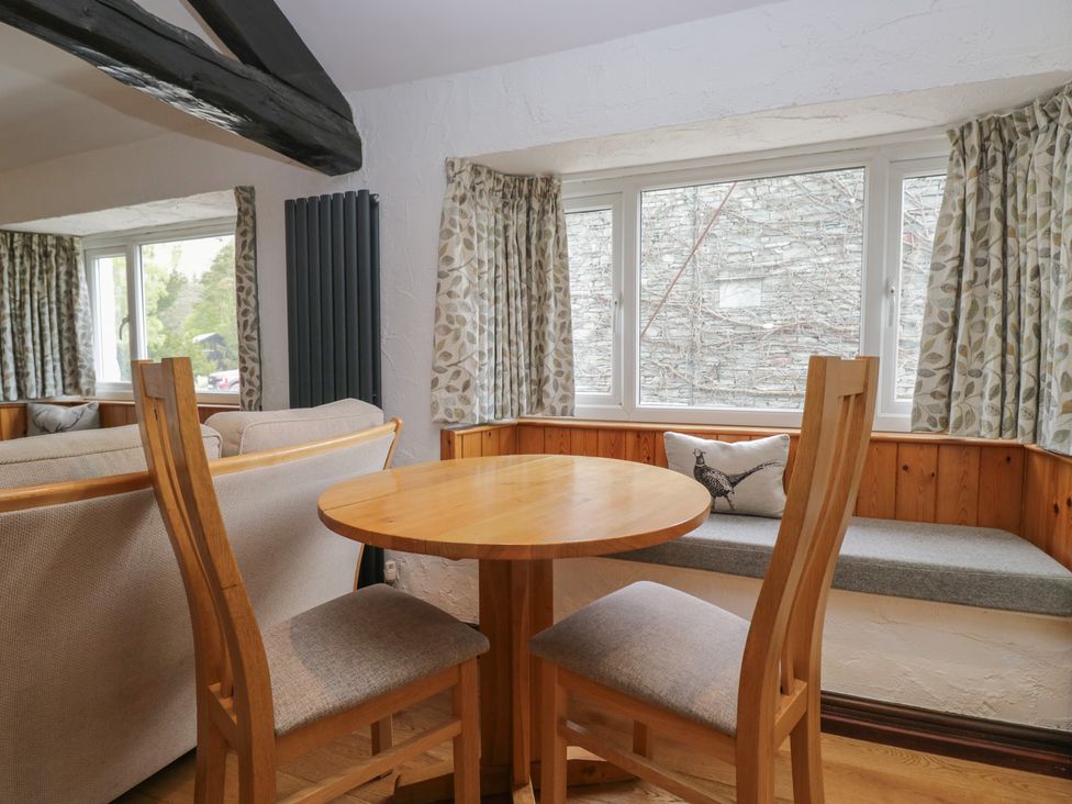 A dining area with a table and chairs at Woodloft Cottage Elterwater near Chapel Stile