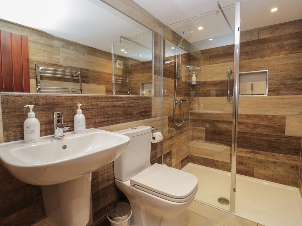 A bathroom featuring a shower, sink, and toilet at Woodloft Cottage Elterwater near Chapel Stile