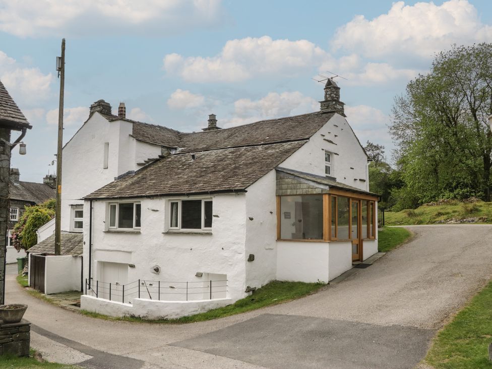 Exterior view of a house with a pathway and trees at Woodloft Cottage Elterwater near Chapel Stile