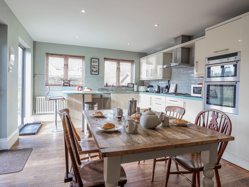 A kitchen with a table and chairs at Holly Lodge in Aldeburgh