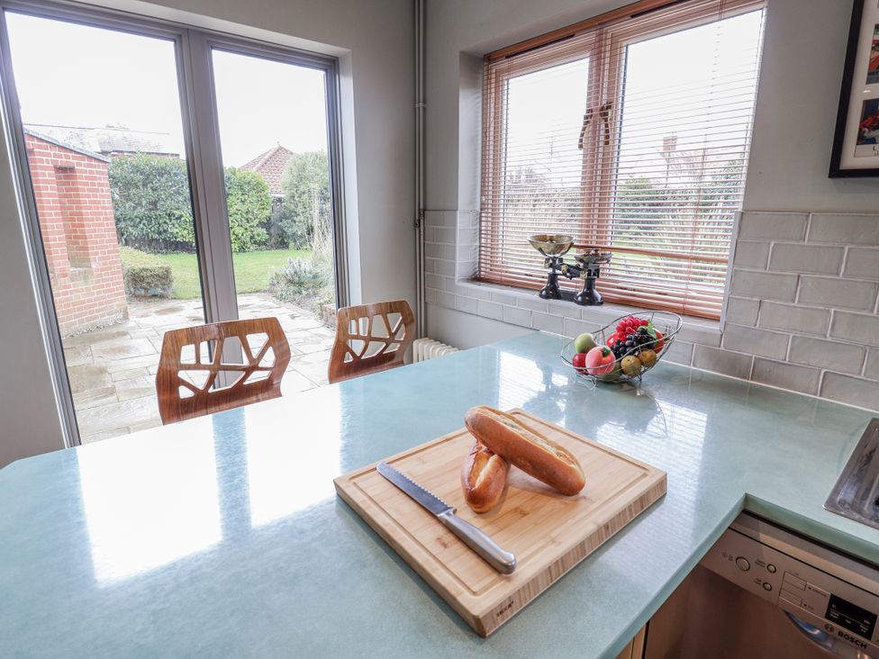 A kitchen with a cutting board and fruit bowl at Holly Lodge in Aldeburgh