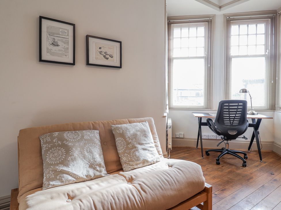 A living room with a sofa and desk at Holly Lodge in Aldeburgh