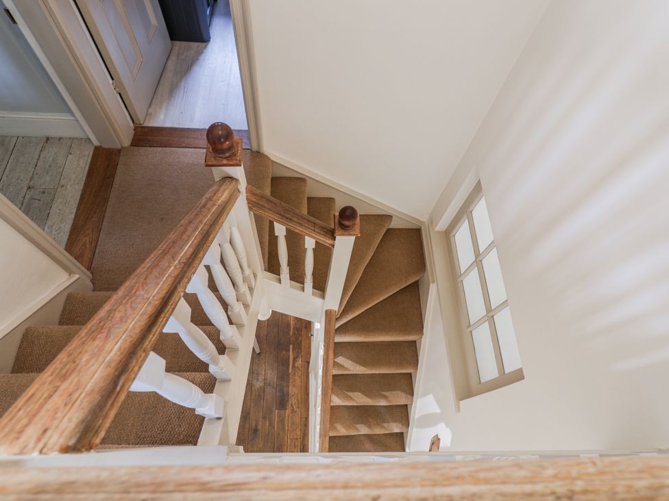 A staircase with railing and carpet at Holly Lodge in Aldeburgh