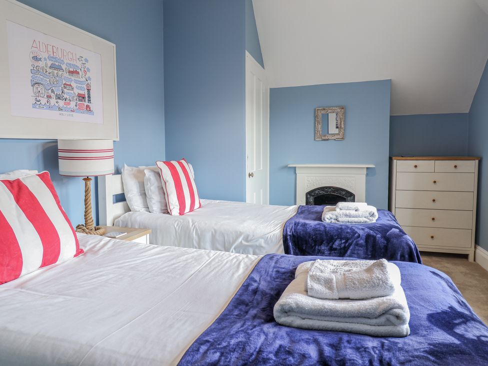 A bedroom with two beds and a dresser at Holly Lodge in Aldeburgh