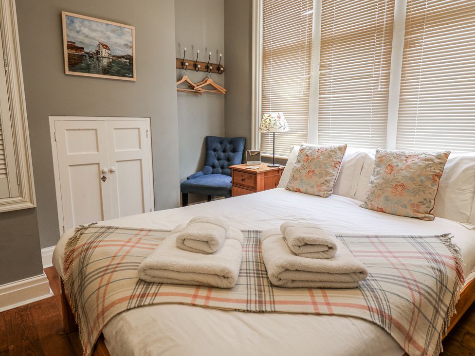 A bedroom with a bed and towels on top at Holly Lodge in Aldeburgh