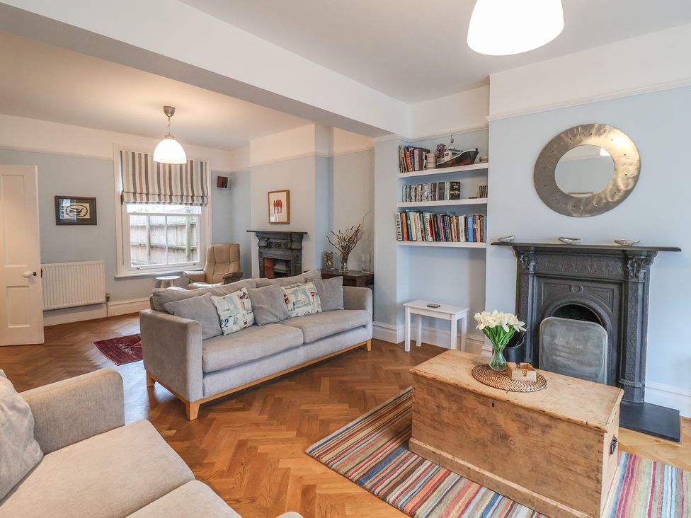 A living room with a coffee table and bookshelves at Lavender House, Aldeburgh