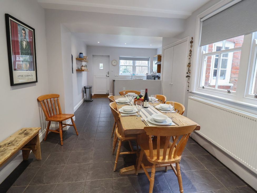 A dining table set with plates in a kitchen at Lavender House, Aldeburgh