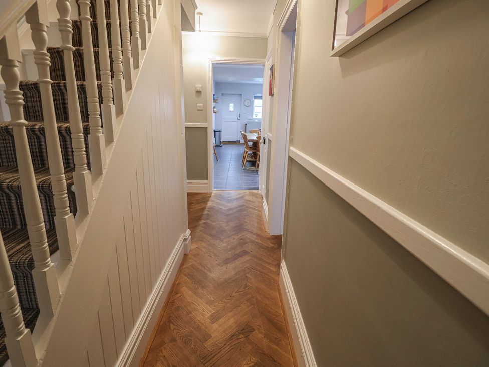 A hallway with staircase and door at Lavender House, Aldeburgh