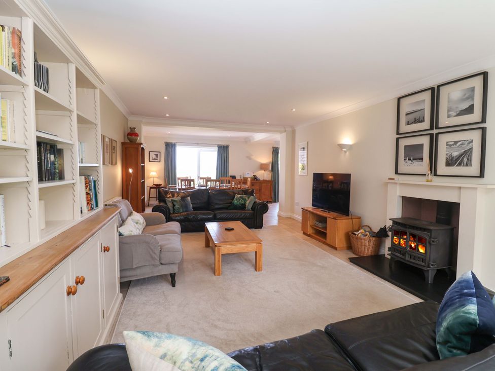 A living room with a television, sofa and dining area at Seadrift Dunwich Near Westleton