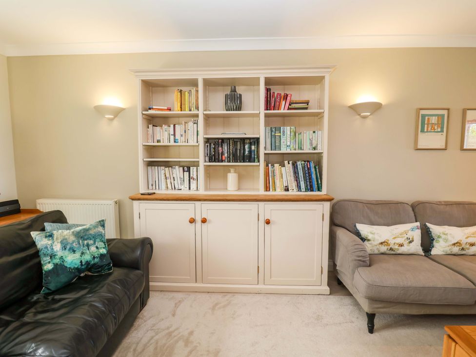 A living room with a bookshelf and seating area at Seadrift Dunwich Near Westleton