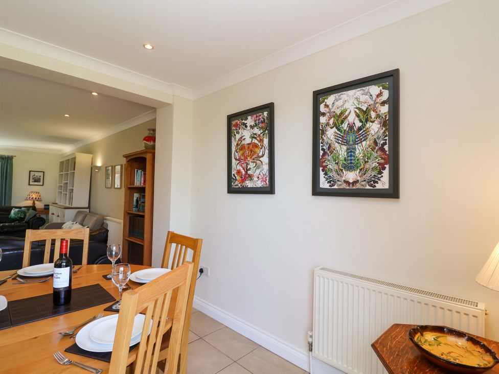 A dining room with a wooden table and wall art at Seadrift Dunwich Near Westleton