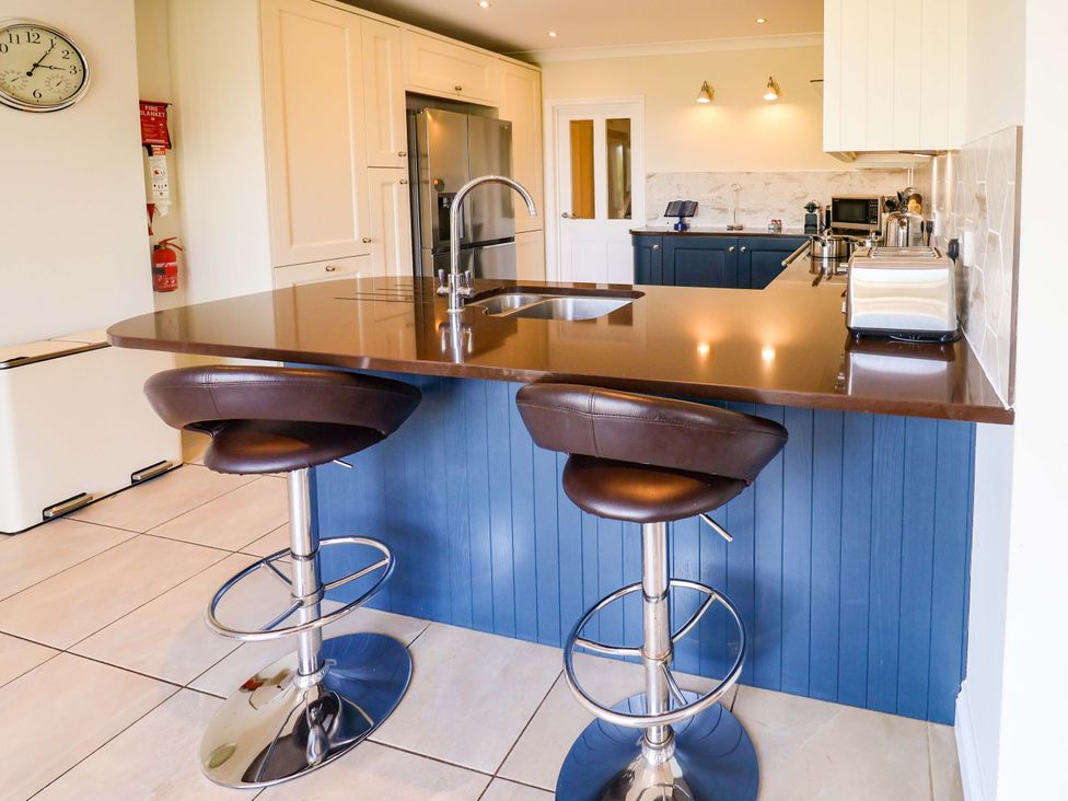 A kitchen with bar stools and a countertop at Seadrift Dunwich Near Westleton