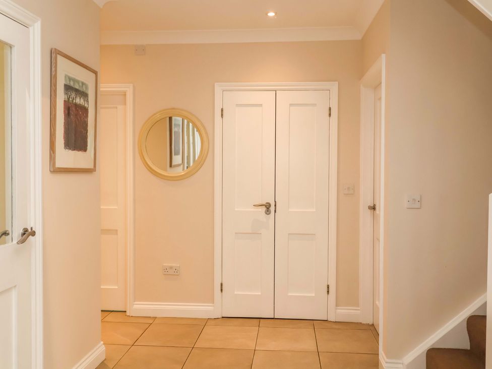 A hallway with double doors and a mirror at Seadrift Dunwich Near Westleton