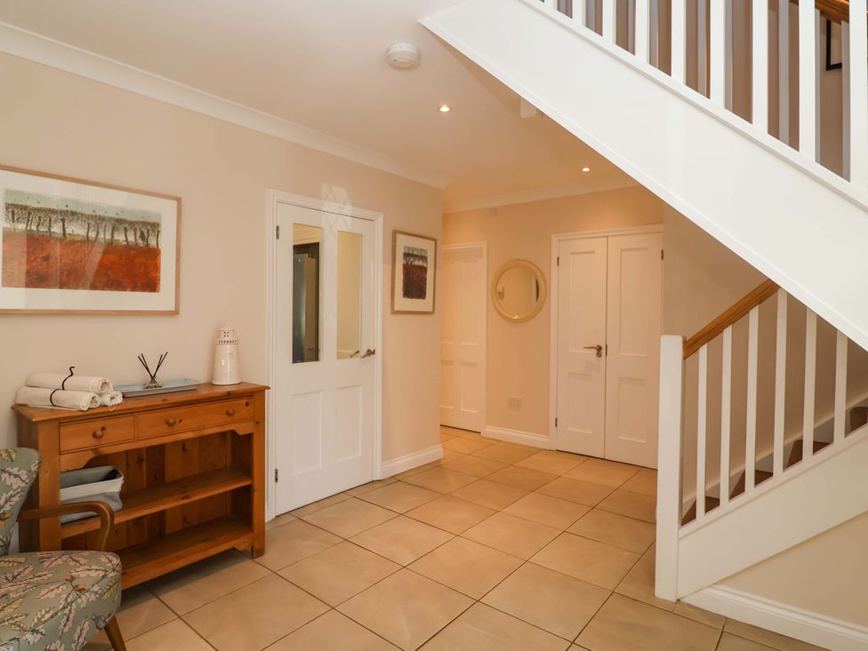 A hallway with a table and towels at Seadrift in Dunwich Near Westleton