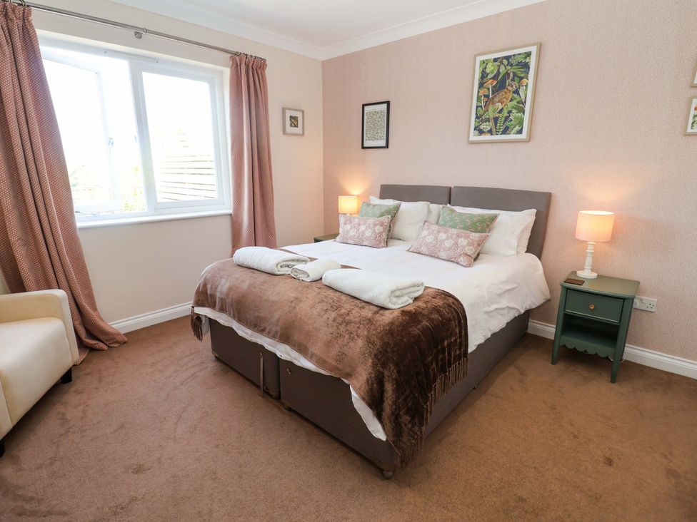 A bedroom with a bed and bedside table at Seadrift in Dunwich Near Westleton