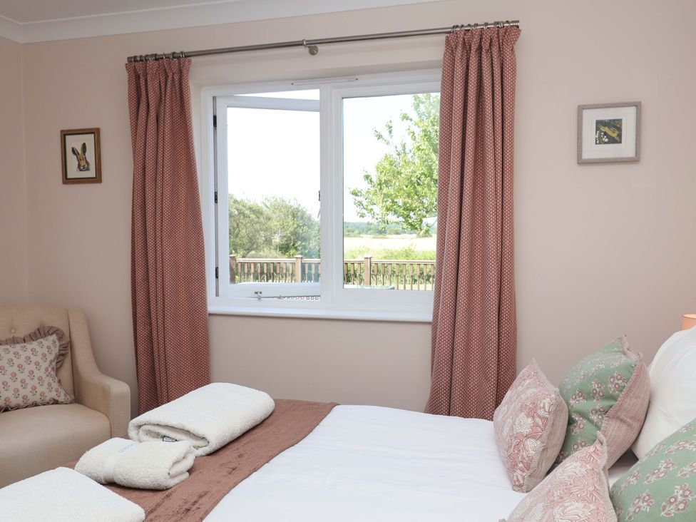 A bedroom with a bed and sofa at Seadrift Dunwich Near Westleton