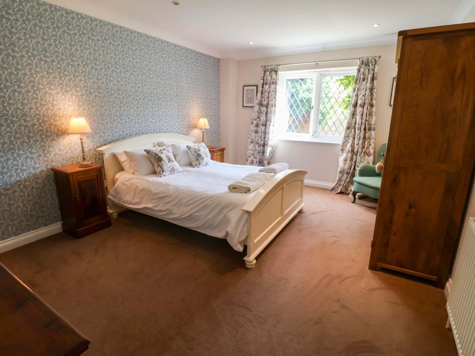 A bedroom with a bed and nightstand at Seadrift in Dunwich Near Westleton