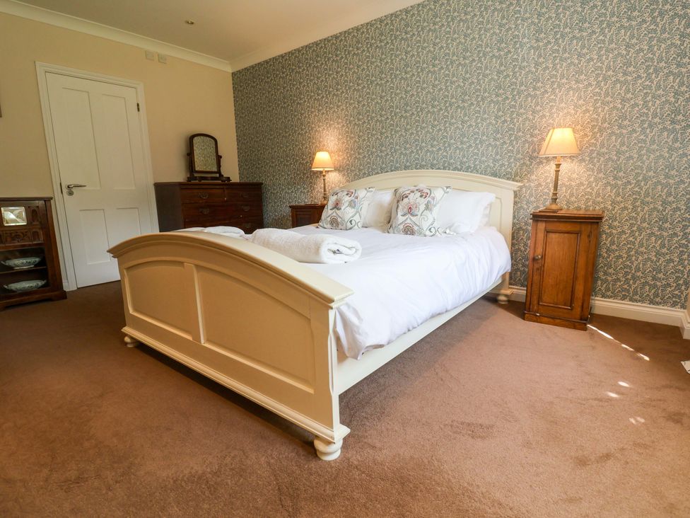A bedroom with a bed, bedside tables, lamps and a chest of drawers at Seadrift Dunwich Near Westleton
