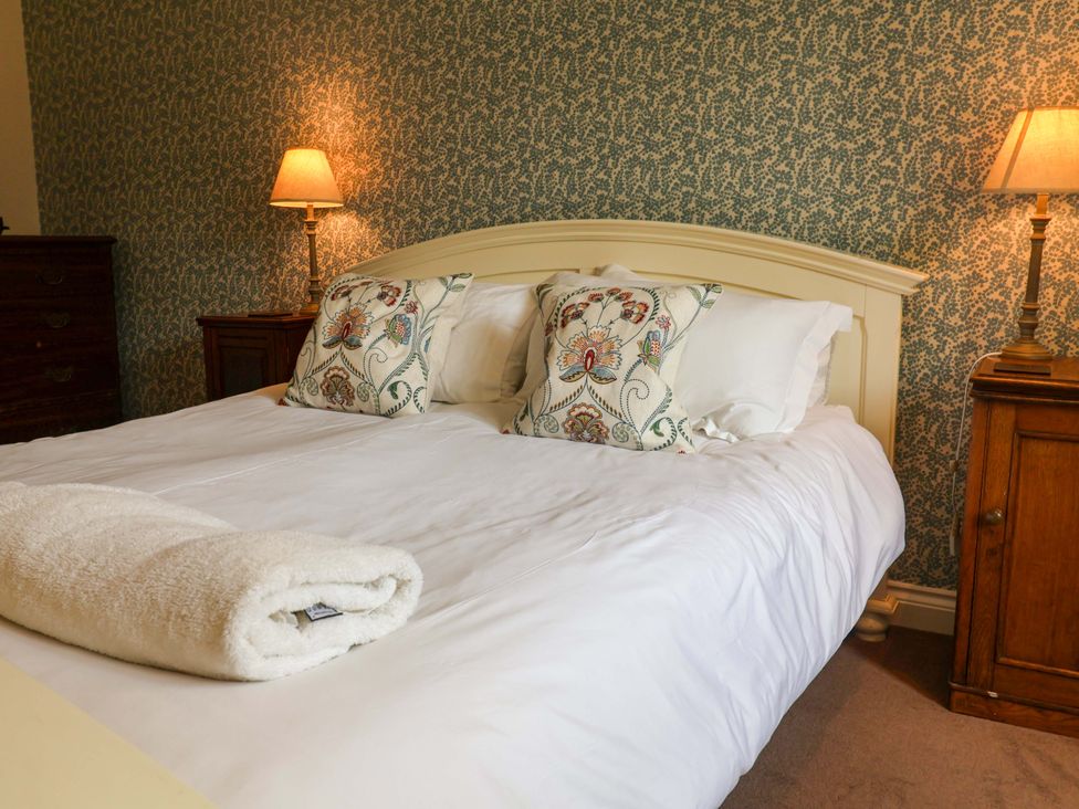 A bedroom with a bed and bedside lamp at Seadrift in Dunwich Near Westleton