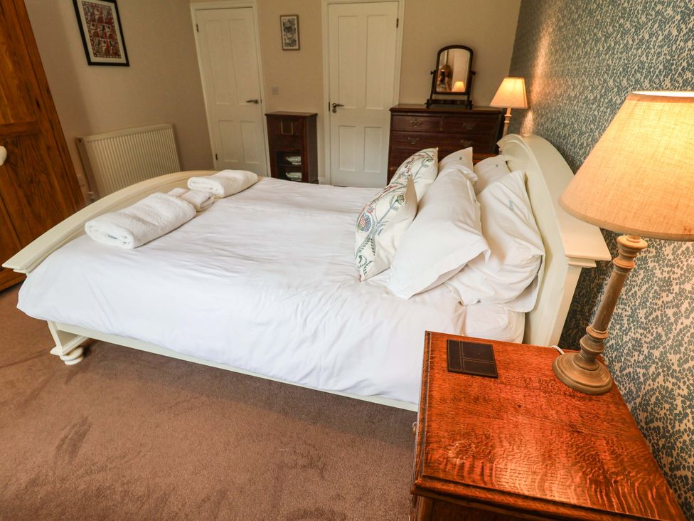 A bedroom with a bed and bedside table at Seadrift in Dunwich Near Westleton