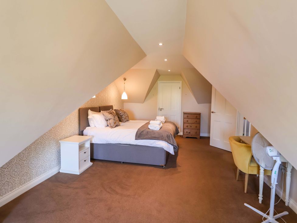 A bedroom with a bed and nightstand at Seadrift in Dunwich Near Westleton