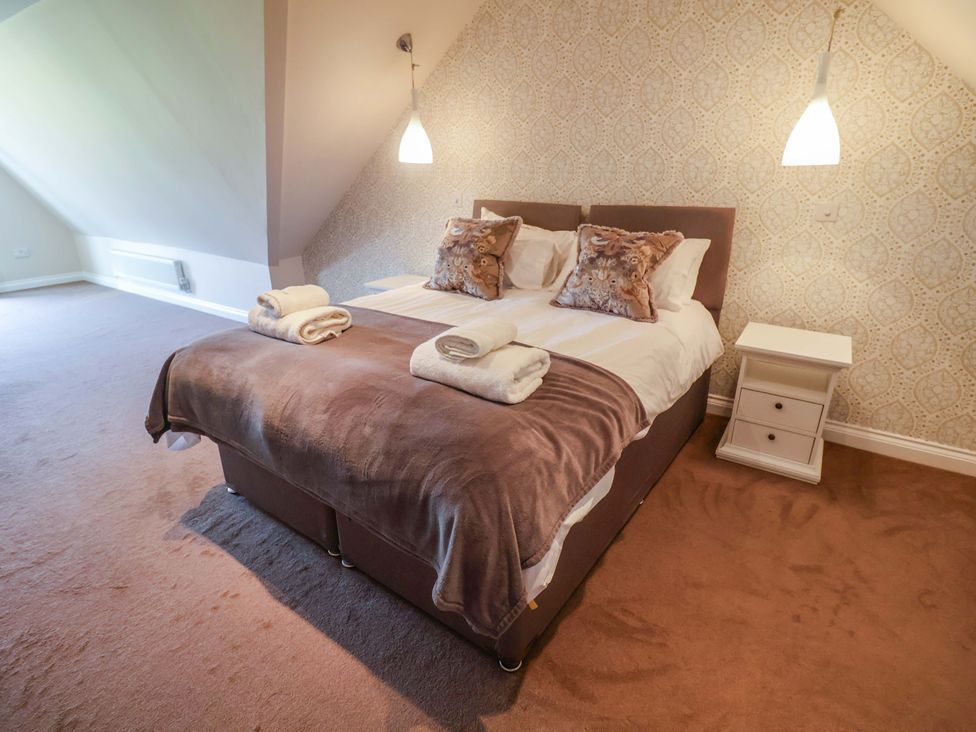 A bedroom with a bed and nightstand at Seadrift in Dunwich Near Westleton