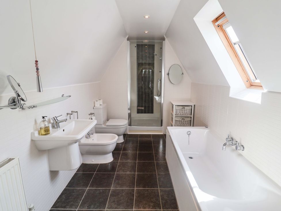 A bathroom with a bathtub, shower, sink and toilet at Seadrift in Dunwich Near Westleton