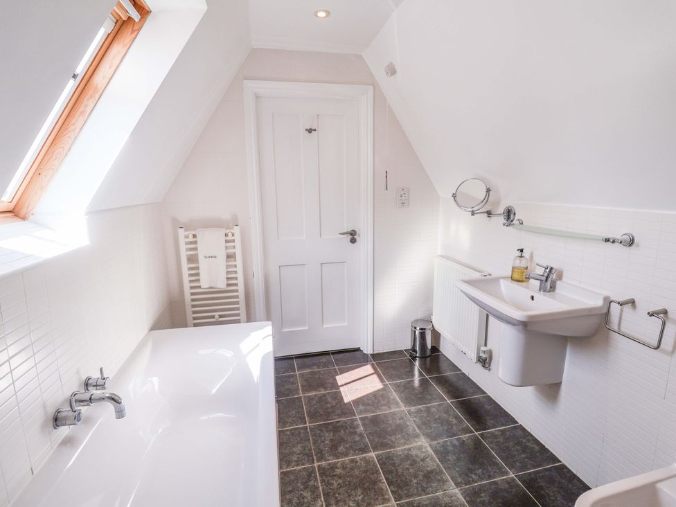 A bathroom with a bathtub and sink at Seadrift in Dunwich Near Westleton