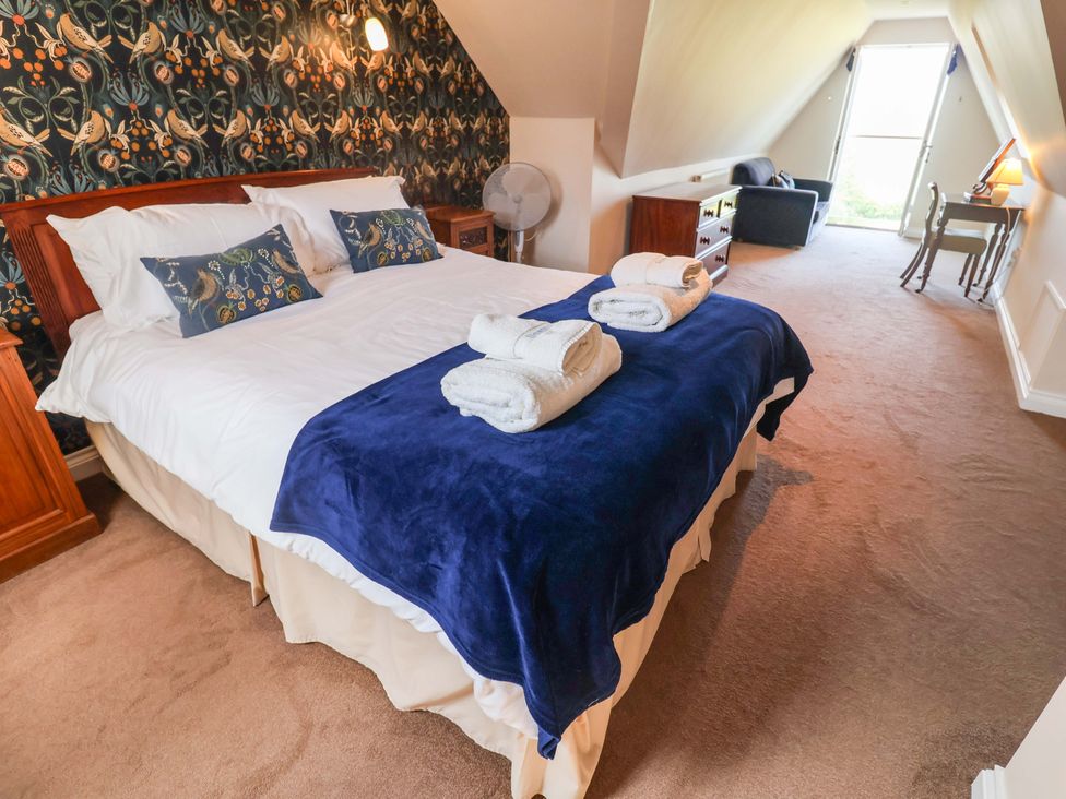 A bedroom with a bed and a fan at Seadrift in Dunwich Near Westleton