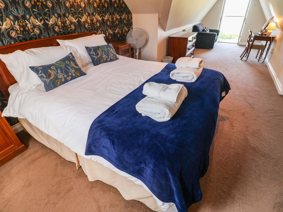 A bedroom with a bed and desk at Seadrift Dunwich Near Westleton
