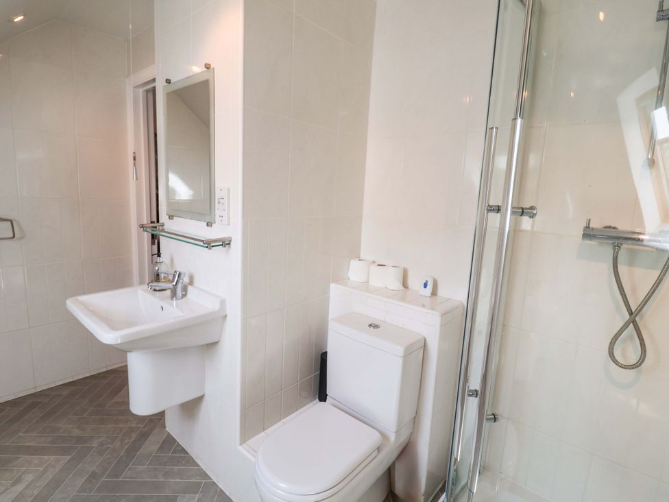 A bathroom with a sink, toilet, and shower at Seadrift in Dunwich Near Westleton