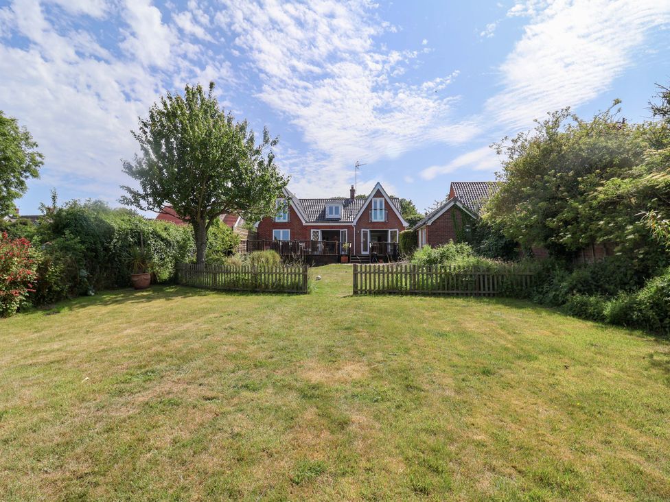 A garden with a house and trees at Seadrift in Dunwich Near Westleton