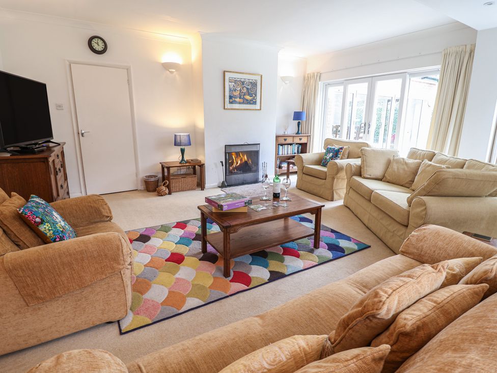 A living room with a fireplace and seating area at Rippleway, Walberswick