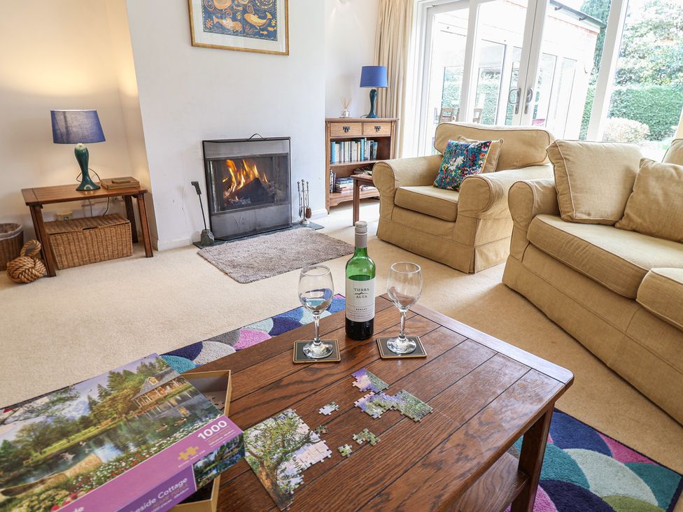 A living room with a fireplace, sofa, and coffee table at Rippleway, Walberswick