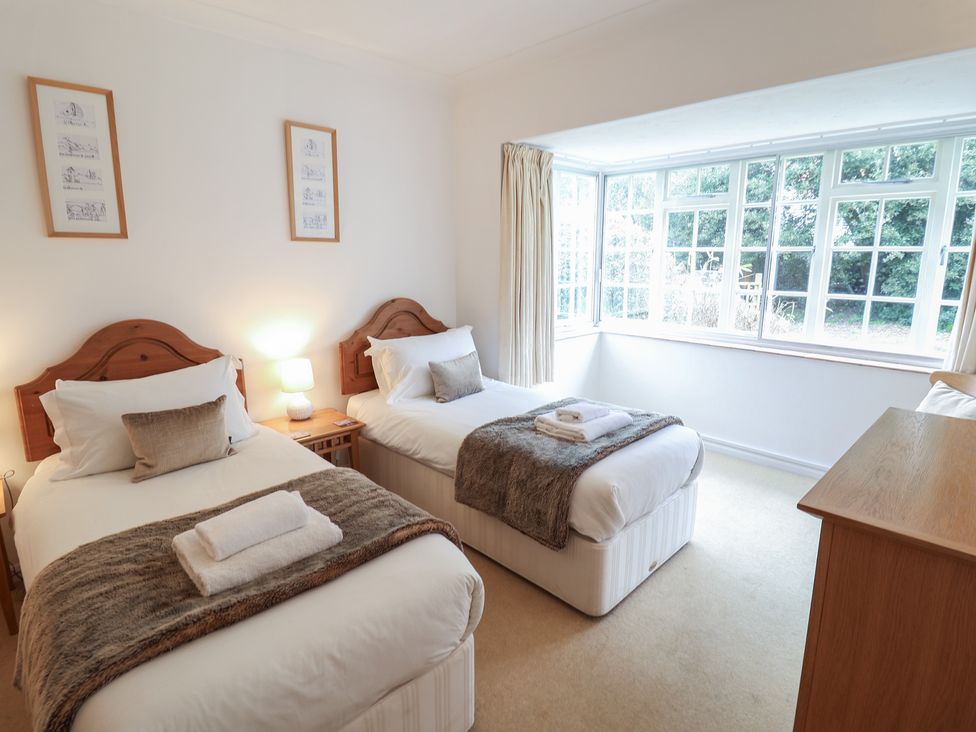 A bedroom with two single beds and a window at Rippleway, Walberswick