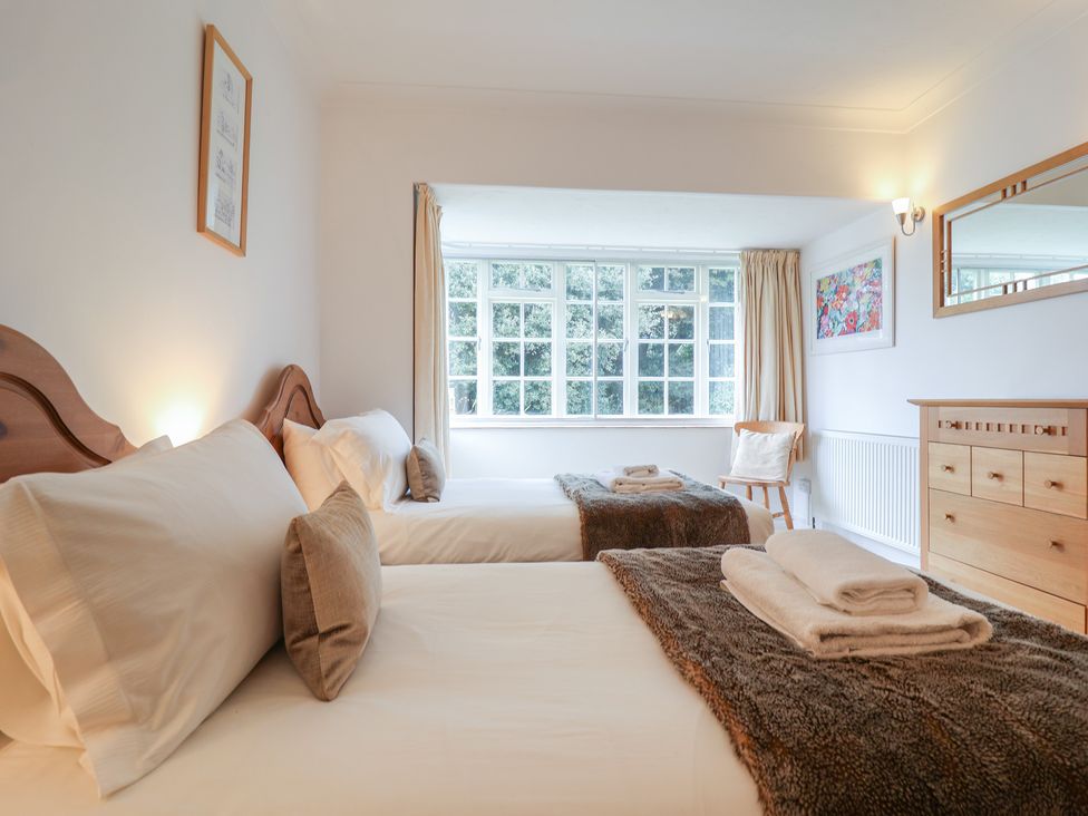 A bedroom with two beds and a window at Rippleway, Walberswick