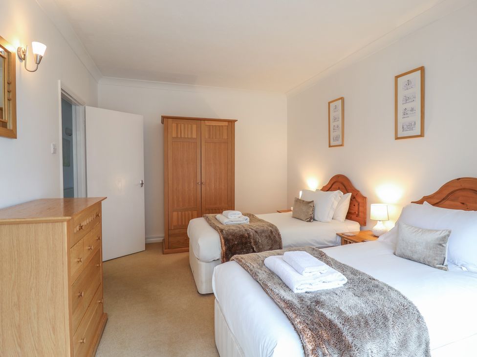 A bedroom with two beds and a wardrobe at Rippleway, Walberswick