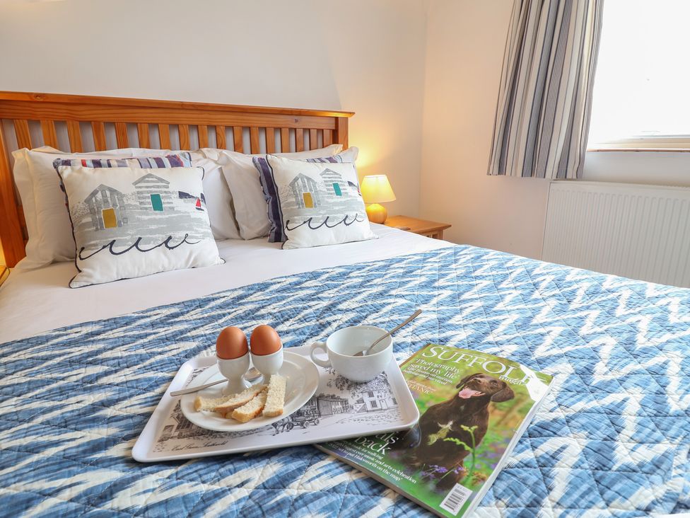 A bedroom with a bed and breakfast tray at Rippleway, Walberswick