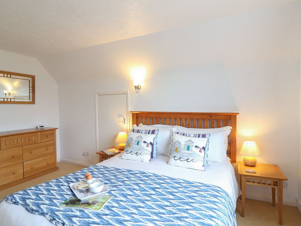 A bedroom with a bed and bedside table at Rippleway, Walberswick