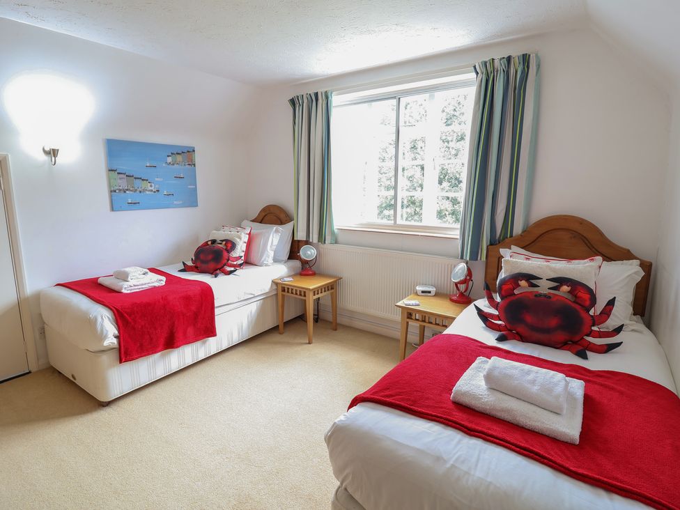A bedroom with two beds and a window at Rippleway, Walberswick