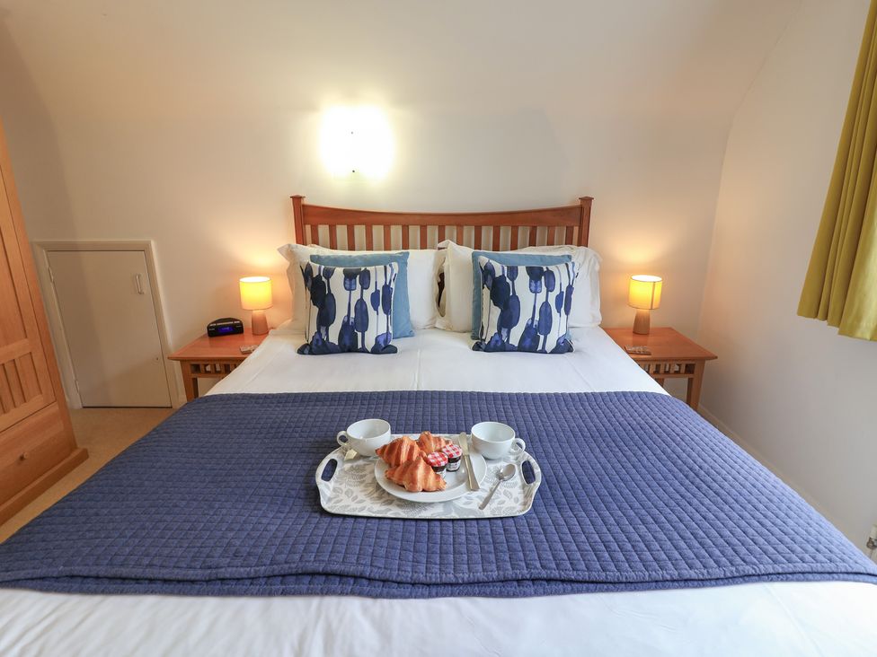 A bedroom with a bed and breakfast items at Rippleway, Walberswick