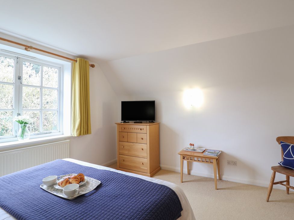 A bedroom with a bed and dresser at Rippleway, Walberswick