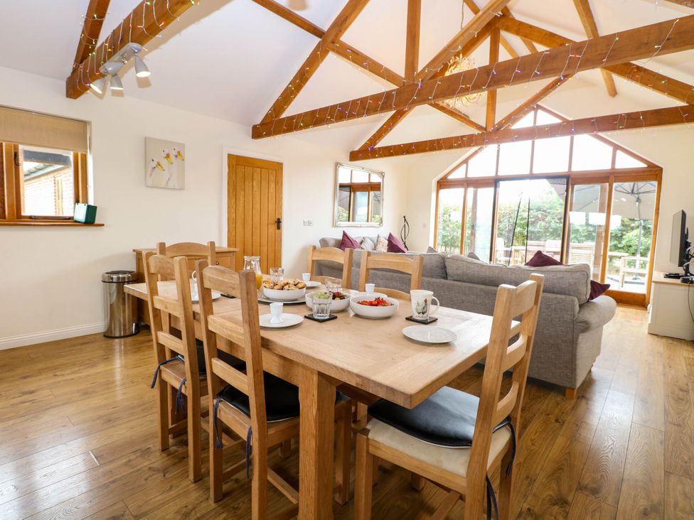 A dining room with a wooden table and chairs at The Mulberry, nr Bungay